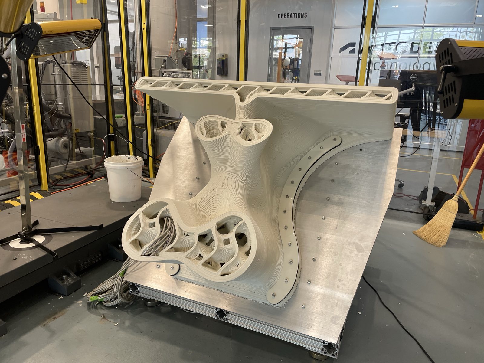 A printed bridge abutment section bolted to an aluminium base plate, showing the cellular internal geometry
